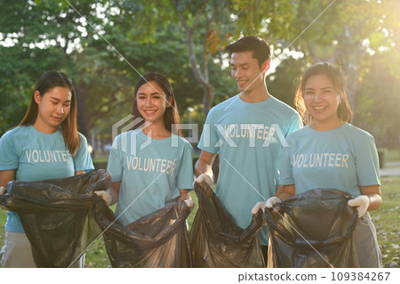 Team of young volunteers with garbage bags cleaning up the forest together Team of young volunteers with garbage bags cleaning up the forest together 109384267