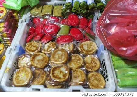 Many varieties of traditional snacks sold in the Marketplace in dawn time in Surabaya, East Java, Indonesia. Many varieties of traditional snacks sold in the Marketplace in dawn time in Surabaya, East Java, Indonesia. 109384373