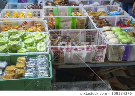 Many varieties of traditional snacks sold in the Marketplace in dawn time in Surabaya, East Java, Indonesia. Many varieties of traditional snacks sold in the Marketplace in dawn time in Surabaya, East Java, Indonesia. 109384376