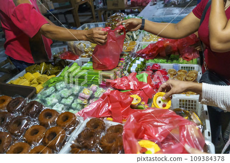 Many varieties of traditional snacks sold in the Marketplace in dawn time in Surabaya, East Java, Indonesia. Many varieties of traditional snacks sold in the Marketplace in dawn time in Surabaya, East Java, Indonesia. 109384378