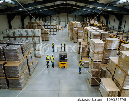 Top view of warehouse workers in warehouse. Team of warehouse workers preparing products for shipment, checking delivery, stock in warehouse. 109384796