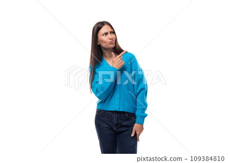 young beautiful european brunette woman dressed in a blue cardigan gesturing with her hands pointing 109384810