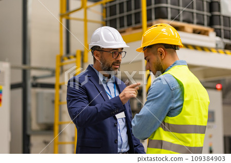 Supervisor, manager scolding employee in modern industry factory. Worker making mistake. Production manger is angry, dissatisfied for worker's poor quality work, safety viaolations. Supervisor, manager scolding employee in modern industry factory. Worker making mistake. Production manger is angry, dissatisfied for worker's poor quality work, safety viaolations. 109384903
