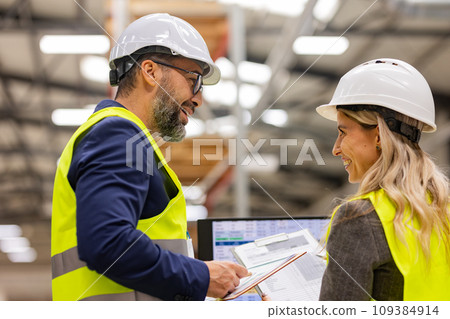 Female engineer and male project manager standing in modern industrial factory, talking about production. Team management in manufacturing facility Female engineer and male project manager standing in modern industrial factory, talking about production. Team management in manufacturing facility 109384914