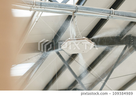 Industrial dust control system in modern manufacturing factory. Dust suppression with water mist, creating fine water mist, moistening dust particles. Industrial dust control system in modern manufacturing factory. Dust suppression with water mist, creating fine water mist, moistening dust particles. 109384989