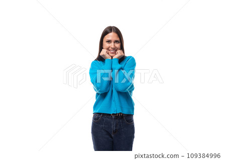 young pleasantly surprised pretty european brunette woman dressed in a blue button-down sweater 109384996