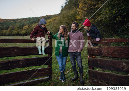 Portrait of family outdoors going on walk in nature. Mother, father and kids spending time outdoors during cold autumn day. Portrait of family outdoors going on walk in nature. Mother, father and kids spending time outdoors during cold autumn day. 109385019