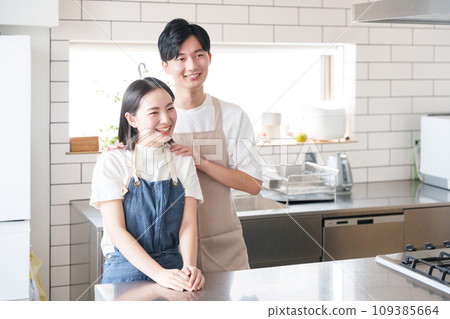 A smiling couple in the kitchen (cooking/housework) A smiling couple in the kitchen (cooking/housework) 109385664