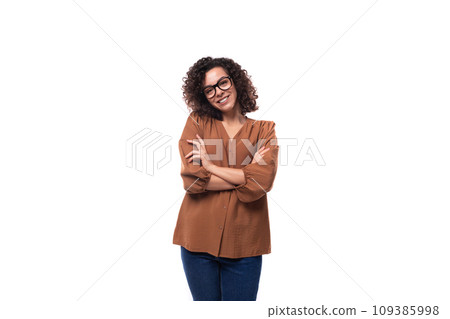 portrait of a young stylish slim brunette woman with curly hair dressed in a brown shirt 109385998