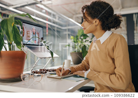 Female freelancer have video conference with client and making notes sitting in cozy coworking Female freelancer have video conference with client and making notes sitting in cozy coworking 109386622