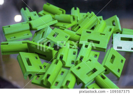 Many green details printed on 3D printer close-up. Parts 3D printed from molten plastic. FDM technologies. Additive progressive modern new technology. 3D printing technology. Innovation prototyping 109387375