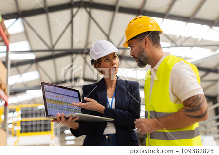 Female manager talking with foreman, checking production plan on notebook. Woman quality controller checking quality of products, talking with technician. 109387823