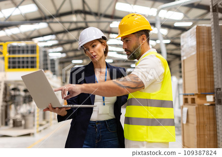 Female manager talking with foreman, checking production plan on notebook. Woman quality controller checking quality of products, talking with technician. Female manager talking with foreman, checking production plan on notebook. Woman quality controller checking quality of products, talking with technician. 109387824