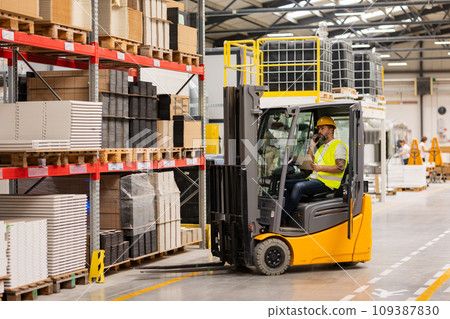 Warehouse worker driving forklift. Warehouse worker preparing products for shipmennt, delivery, checking stock in warehouse, order picking. Warehouse worker driving forklift. Warehouse worker preparing products for shipmennt, delivery, checking stock in warehouse, order picking. 109387830