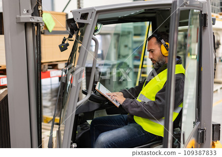 Warehouse worker driving forklift. Forklift driver reading order, order picking. Warehouse worker preparing products for shipmennt, delivery, checking stock in warehouse. Warehouse worker driving forklift. Forklift driver reading order, order picking. Warehouse worker preparing products for shipmennt, delivery, checking stock in warehouse. 109387833