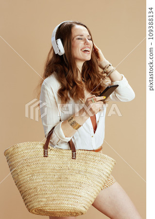 happy trendy woman in blouse and shorts using phone happy trendy woman in blouse and shorts using phone 109388134