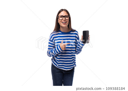 portrait of an optimistic bright european brunette young lady in a blue sweater and jeans holding a 109388184