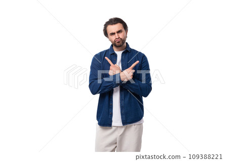 young handsome brunet european guy in a denim shirt over a white t-shirt on a white background 109388221