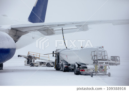 Refueling of airplane at airport during snowfall. 109388916