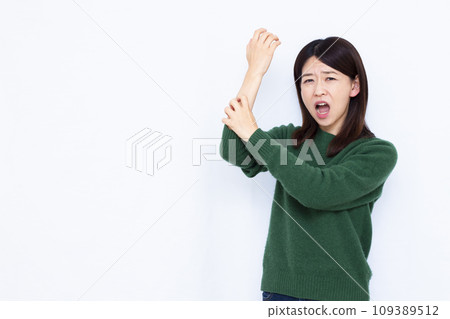 A woman in her 40s scratches her skin due to dryness A woman in her 40s scratches her skin due to dryness 109389512