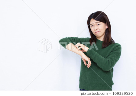 A woman in her 40s scratches her skin due to dryness A woman in her 40s scratches her skin due to dryness 109389520