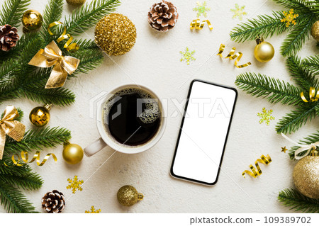 top view of smart phone with hot cup of coffee. Christmas decoration on colored background 109389702