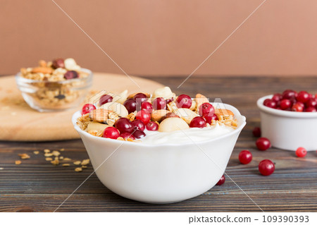 Healthy breakfast food with granola, yogurt, fruits and nuts. Dessert parfait with dried fruits for breakfast 109390393