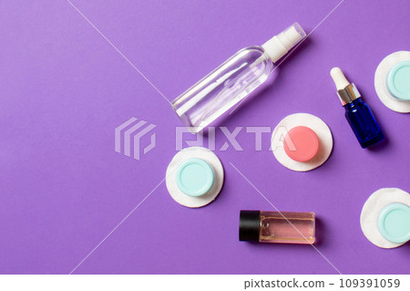 Set of travel size cosmetic bottles on colored background. Flat lay of cream jars. Top view of bodycare style concept 109391059