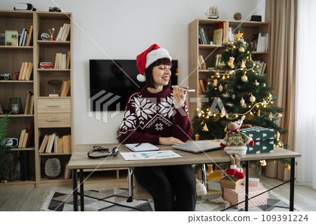 Woman freelancer in Santa hat and casual wear recording audio message Woman freelancer in Santa hat and casual wear recording audio message 109391224