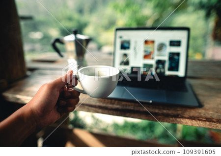 Laptop on table with coffee and stock graphs 109391605