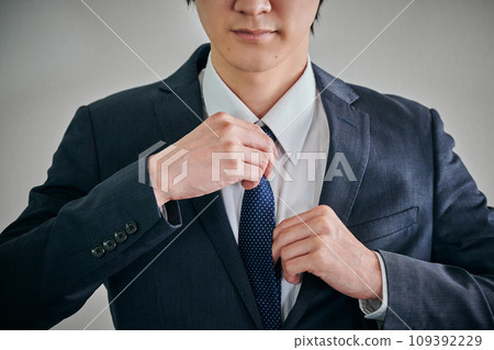 A young man wearing a suit and getting ready 109392229