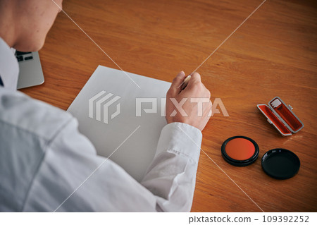 Young man's hand stamping a document Young man's hand stamping a document 109392252