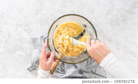 Flat lay. Melting white chocolate chips and other ingredients in a glass mixing bowl over boiling water to prepare cranberry pistachio fudge. 109392278