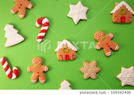 Tasty gingerbread cookies on green background 109392406