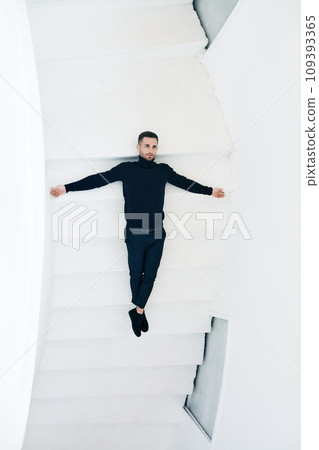 Man in Black Outfit Lying on White Staircase Man in Black Outfit Lying on White Staircase 109393365