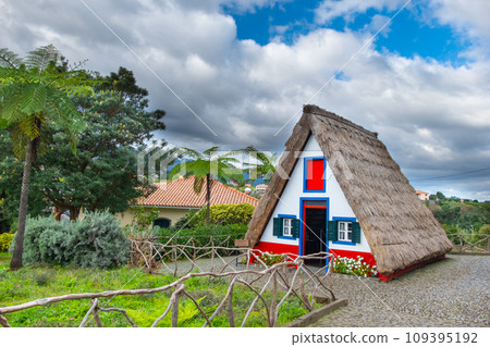 Traditional hut houses and garden of Madeira in village Santana. Sunny day in Portugal, tourist destination Traditional hut houses and garden of Madeira in village Santana. Sunny day in Portugal, tourist destination 109395192