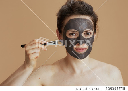 young woman with brush and facial mask 109395756