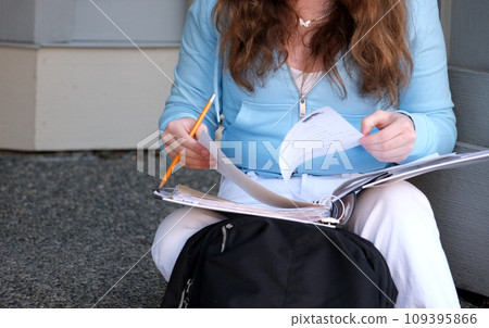 young girl teenager sits on porch in hands with a folder, a magazine and pencil, do homework, solve problems, wait at the door, a beautiful woman, young white jeans, a briefcase, think, work, study 109395866