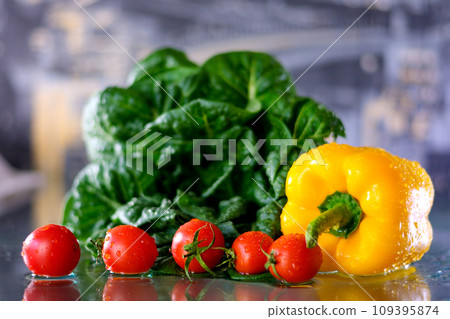Closeup on vegetables on cutting board and young housewife in background Assortment of fresh vegetables at market Closeup on vegetables on cutting board and young housewife in background Assortment of fresh vegetables at market 109395874