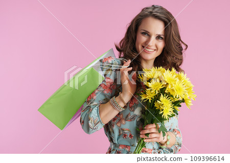 Portrait of happy 40 years old woman in floral dress on pink 109396614