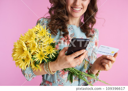 Smiling elegant woman using smartphone applications on pink 109396617