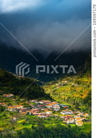 Traditional terrace village Sao Vicente, Madeira Island, Portugal. Small houses and gardens among a green mountain landscape in stormy weather. Traditional terrace village Sao Vicente, Madeira Island, Portugal. Small houses and gardens among a green mountain landscape in stormy weather. 109397179