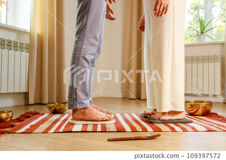 couple in love morning yoga practice with sadhu nails. mans and womans foot on the wooden desk with sharp metal nails couple in love morning yoga practice with sadhu nails. mans and womans foot on the wooden desk with sharp metal nails 109397572