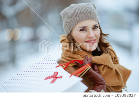 happy stylish woman in brown hat and scarf in camel coat 109398027