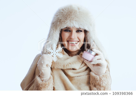 happy modern woman in winter coat and fur hat on white 109398366