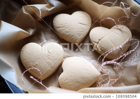 Heart shaped cookies on baking parchment paper 109398504
