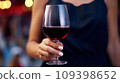 Female hand holds one glass goblet with white wine. 109398652