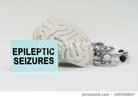 On a white surface next to the brain there is a stethoscope and stickers with the inscription - epileptic seizures 109398697