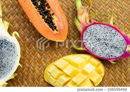 Delicious Exotic Tropic Fruits Top View on Wicker Mat Background Delicious Exotic Tropic Fruits Top View on Wicker Mat Background 109399499