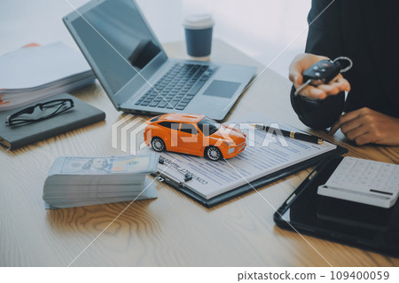 Salesman send key to customer after good deal agreement, successful car loan contract buying or selling new vehicle. Salesman send key to customer after good deal agreement, successful car loan contract buying or selling new vehicle. 109400059